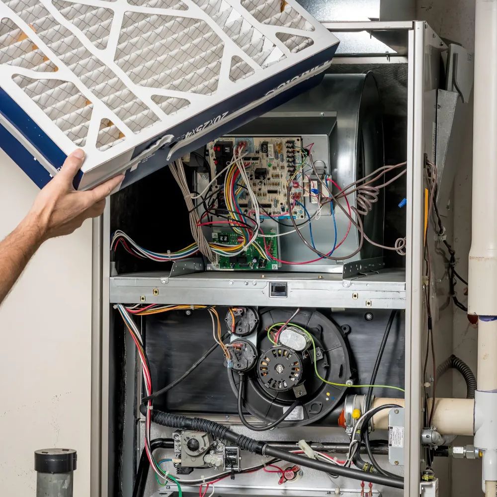 Technician servicing HVAC equipment in a mechanical room